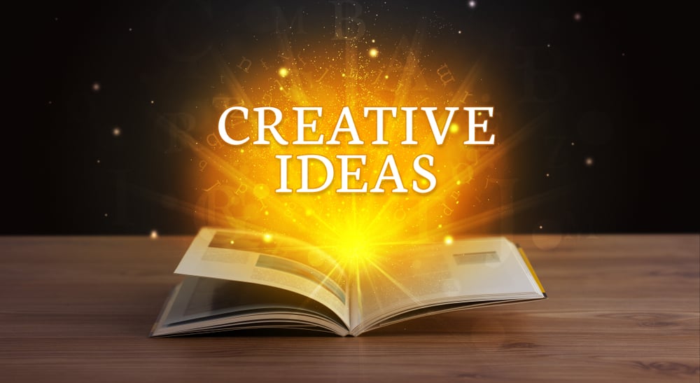 CREATIVE IDEAS inscription coming out from an open book, educational concept