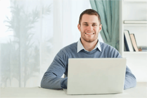 Happy smiling young businessman working in his home office