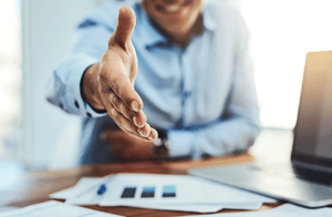 hombre en escritorio con mano extendida