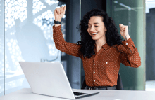 mujer celebrando frente a laptop comisiones programa partners