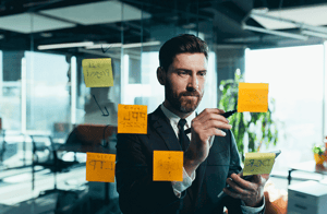 hombre de traje analizando notas adhesivas estrategias gestion de innovacion