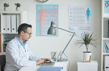 medico usando computador en clinica medica