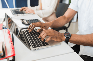 manos sobre teclado de laptop