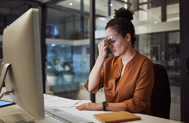 mujer estresada por problemas con vacaciones de empleados frente a computador