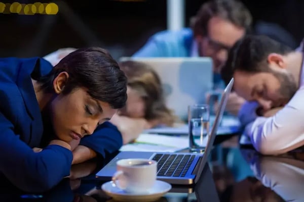 Tired businesspeople sleeping in office at night