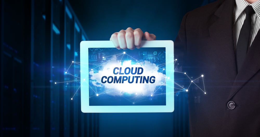 Young business person working on tablet and shows the inscription CLOUD COMPUTING