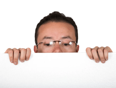 man with glasses peeping over white card over white background 1