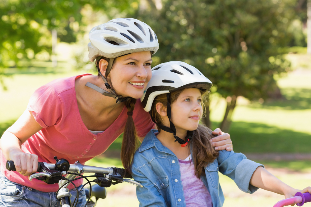Portrait of a smiling woman with her daughter riding bicycles
